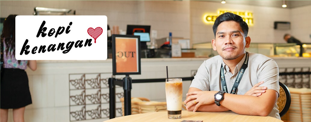 A manager sitting in a cafe with a coffee