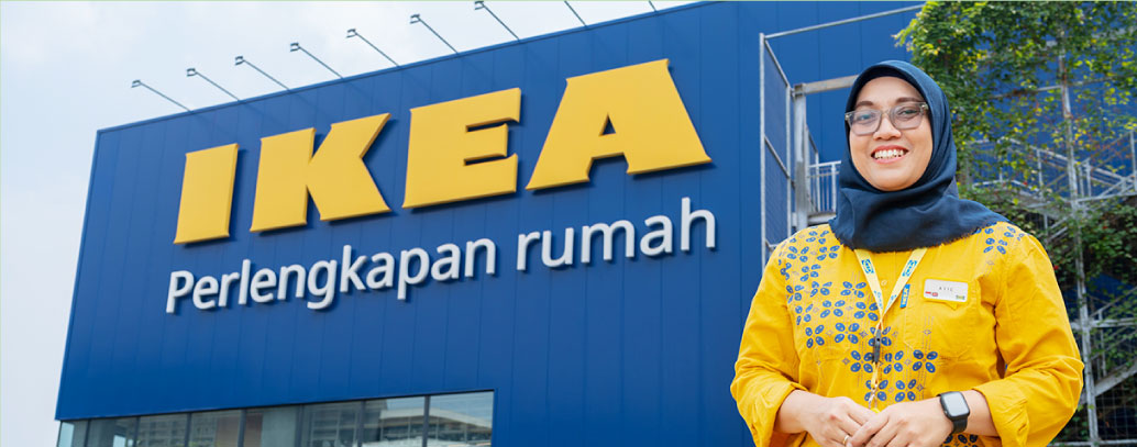 A woman wearing yellow clothing infront of an IKEA store
