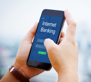 Seseorang sedang memegang handphone untuk mengakses internet banking