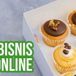 Kotak berisi kue cupcake dengan hiasan cokelat, dilengkapi teks "Tips Bisnis Kue Online".