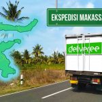 Truk Deliveree melaju di jalan dengan latar belakang pemandangan alam, terdapat peta Sulawesi yang menunjukkan rute pengiriman Makassar-Mamuju, serta papan penunjuk arah bertuliskan 'Ekspedisi Makassar - Mamuju'.