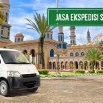 Mobil van Deliveree di depan Masjid Islamic Center Samarinda dengan tulisan 'Jasa Ekspedisi Samarinda' di papan hijau.