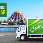 Truk dengan stiker Deliveree di jalanan untuk ekspedisi Makassar dengan latar belakang masjid 99 kubah.