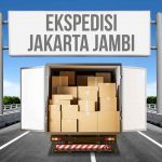 Truk dengan pintu terbuka memperlihatkan kotak-kotak barang di jalan, disertai papan bertuliskan 'Ekspedisi Jakarta Jambi'