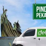 Van Deliveree di depan monumen ikon Pekanbaru dengan papan bertuliskan 'Pindahan Pekanbaru'.