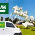 Mobil Deliveree melintas di dekat patung kuda dengan papan arah bertuliskan "Tangerang."