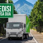 Truk ekspedisi Deliveree melintas di jalur Kuta-Nusa Dua dengan latar pegunungan.