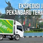 Truk Deliveree melintas di jalan dengan latar belakang patung ikonik Pekanbaru dan tulisan "Ekspedisi Jakarta Pekanbaru Terjangkau."