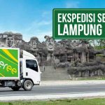 Truk Deliveree melintasi jalan di depan Monumen Empat Marga Lampung, terdapat tulisan “Ekspedisi Semarang Lampung 24 Jam” di pojok kanan atas.