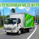Truk Deliveree melintasi jalan raya yang ada di area Pekutatan Bali dengan tulisan “Ekspedisi Pengiriman Medewi Pekutatan” di kanan atas.
