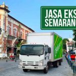 Truk Deliveree melewati Kota Lama Semarang dengan bangunan kuno Harba di belakangnya, terdapat tulisan “Jasa Ekspedisi Semarang Jambi” di kanan atas.