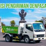 Truk Bak Deliveree melintasi patung batu di tengah bundaran jalan yang merepresentasikan hinduisme di daerah Denpasar Bali, terdapat tulisan “Ekspedisi Pengiriman Denpasar Ubud” di kanan atas
