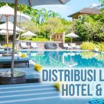 Pemandangan area santai hotel & resort yang indah di Bali dengan kolam renang dan kursi panjang berpayung, terdapat tulisan Distribusi Logistik Hotel & Resort” di kiri atas.