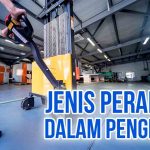Pekerja menggunakan alat pemindah barang di gudang untuk memudahkan pengiriman.