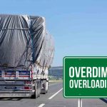 Truk ODOL (Overdimension Overloading) di jalan raya dengan muatan besar yang ditutupi terpal.