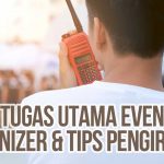 Seorang staff event organizer menggunakan walkie-talkie untuk berkomunikasi di tengah acara dan memastikan kelancaran logistik sebagai ilustrasi “Event Organizer (EO): 5 Tugas Utama + Tips Pengiriman“