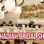 Dekorasi pesta dengan balon dan meja bertema bridal shower serta tulisan "12 Ide Hadiah Bridal Shower".