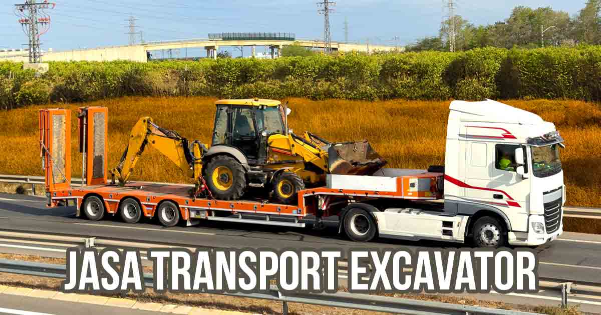 Truk trailer membawa excavator di jalan tol.