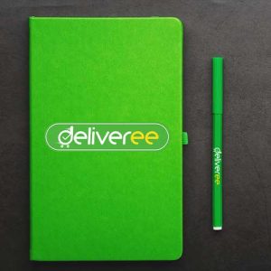 Buku dan pulpen dengan logo perusahaan sebagai merchandise peusahaan