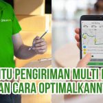 Petugas pengiriman mencatat pesanan di depan tumpukan kardus dan layar ponsel menampilkan peta rute multi drop sebagai ilustrasi “Apa Itu Pengiriman Multi Drop dan Cara Optimalkannya”