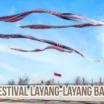 Layang-layang tradisional Bali berukuran besar terbang di langit biru saat Festival Layang-Layang di pantai.