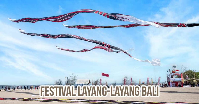 Layang-layang tradisional Bali berukuran besar terbang di langit biru saat Festival Layang-Layang di pantai.