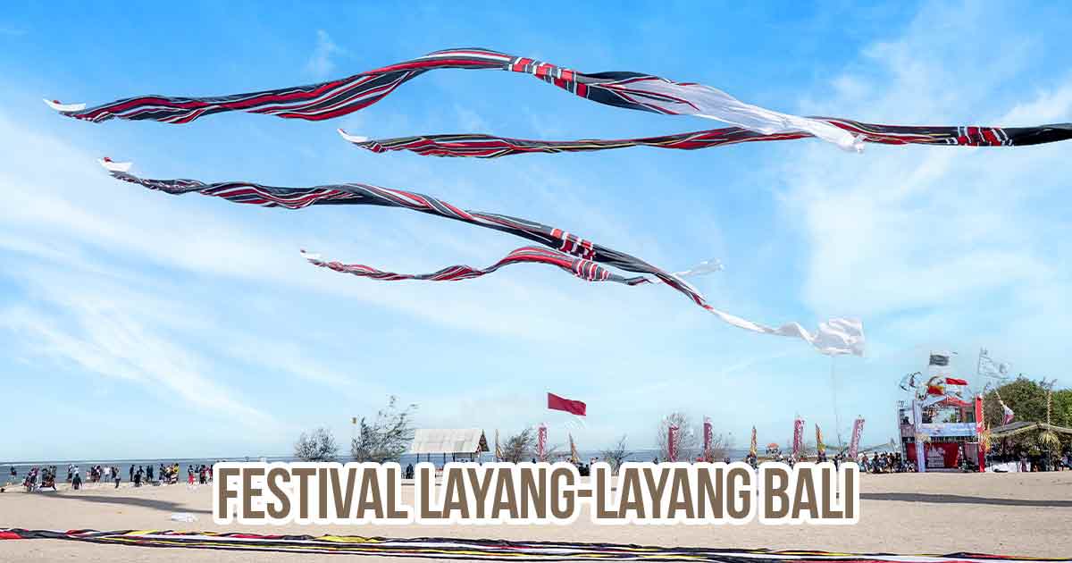Layang-layang tradisional Bali berukuran besar terbang di langit biru saat Festival Layang-Layang di pantai.