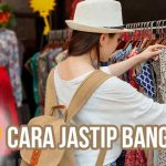 Seorang jastipers wanita sedang memilih baju di pasar atau toko fashion Bangkok untuk layanan jastip.